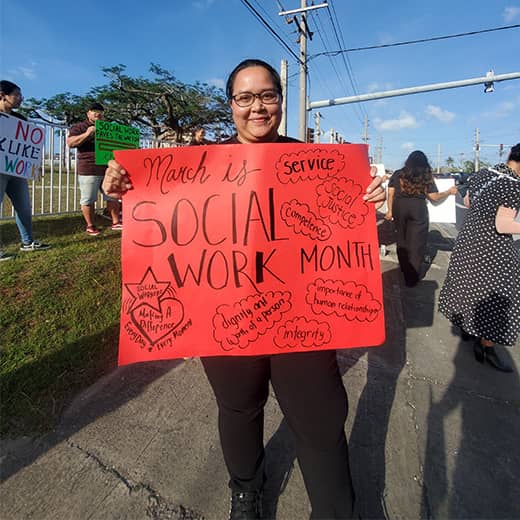 Naomi Ezra holds Social Work Month sign to spread awareness