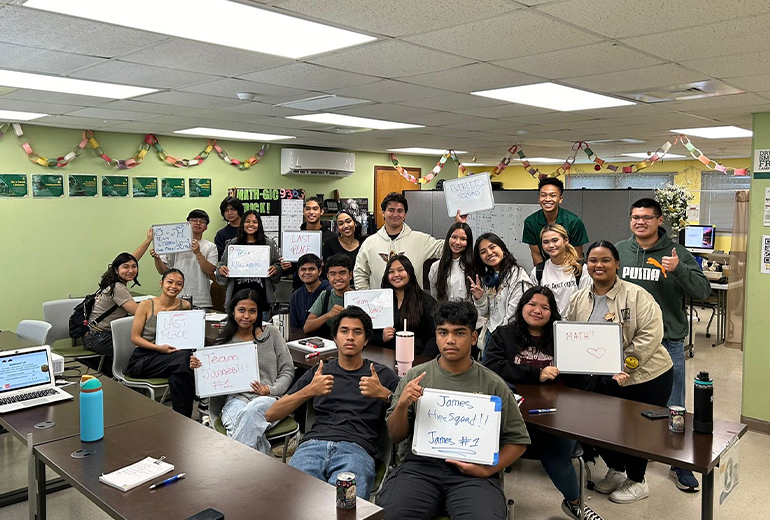 Triton Summer Academy students pose for photo, holding up whiteboards, with tutors