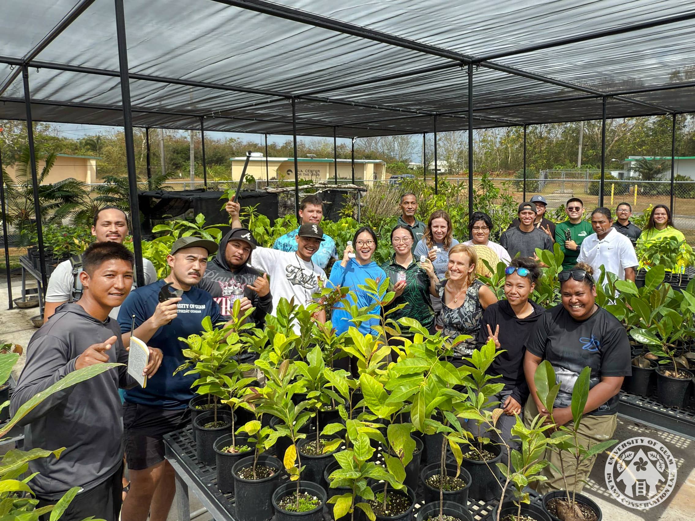 A group posing for a photo in a plant nursery