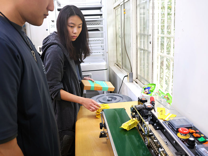 Photo of a woman using a food packaging machine