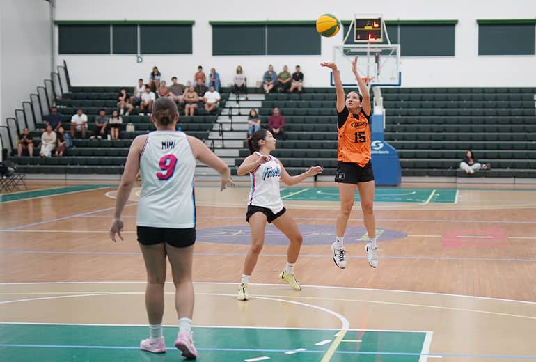 Jia Peters shoots basketball with opponents nearby