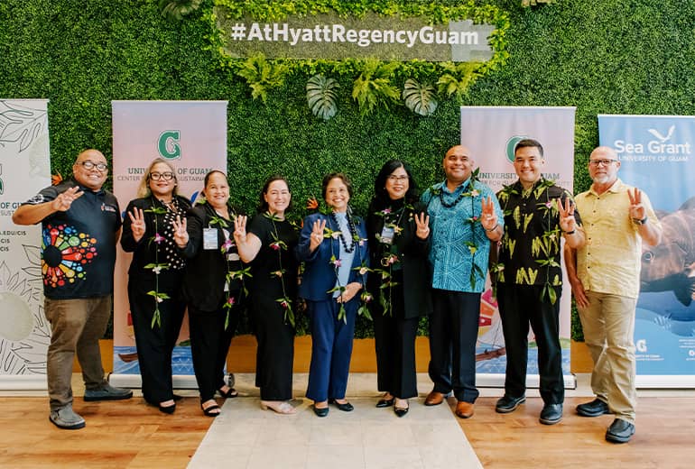 UOG leaders and partners pose for a photo at Hyatt regency photo op area