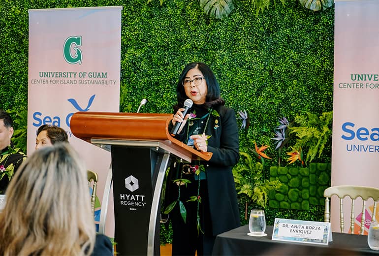 UOG President Anita B. Enriquez speaks at podium at CIS and Sea Grant event at Hyatt Regency Guam