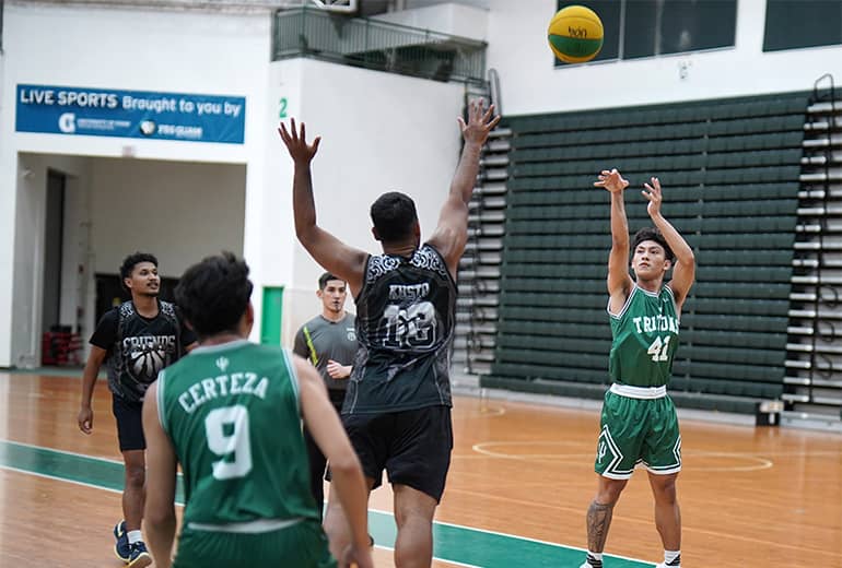 #41 basketball player takes a shot while oponent in black jersey tries to block and initial player’s teammate is behind opponent
