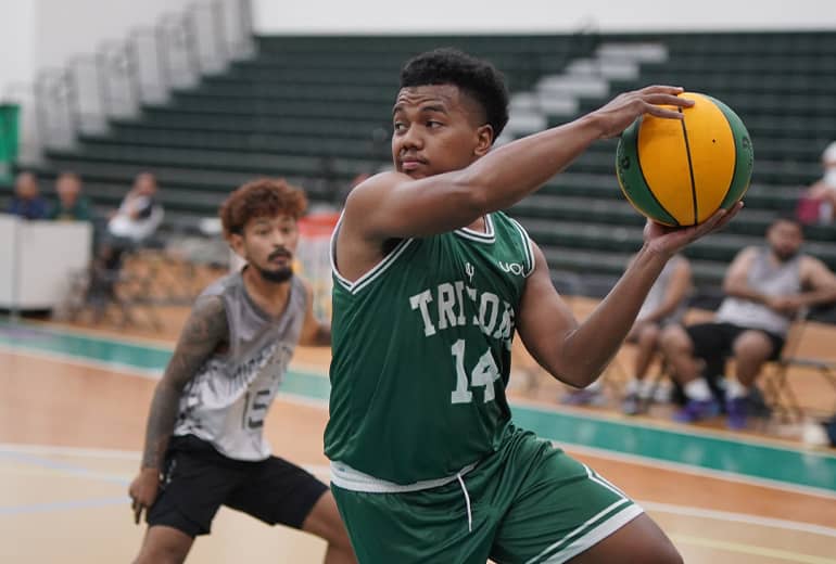 player 14 in green jersey makes a move with basketball