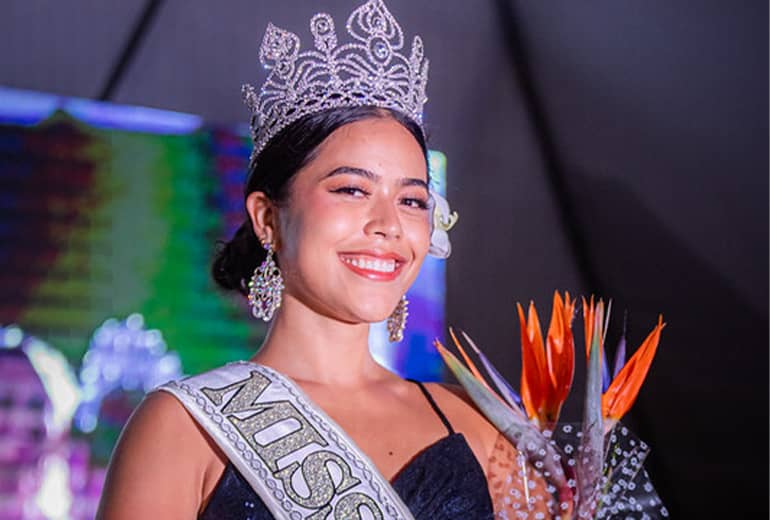 Miss UOG contestant Ashley Topasna poses for photo with Miss UOG sash, flower, and crown.