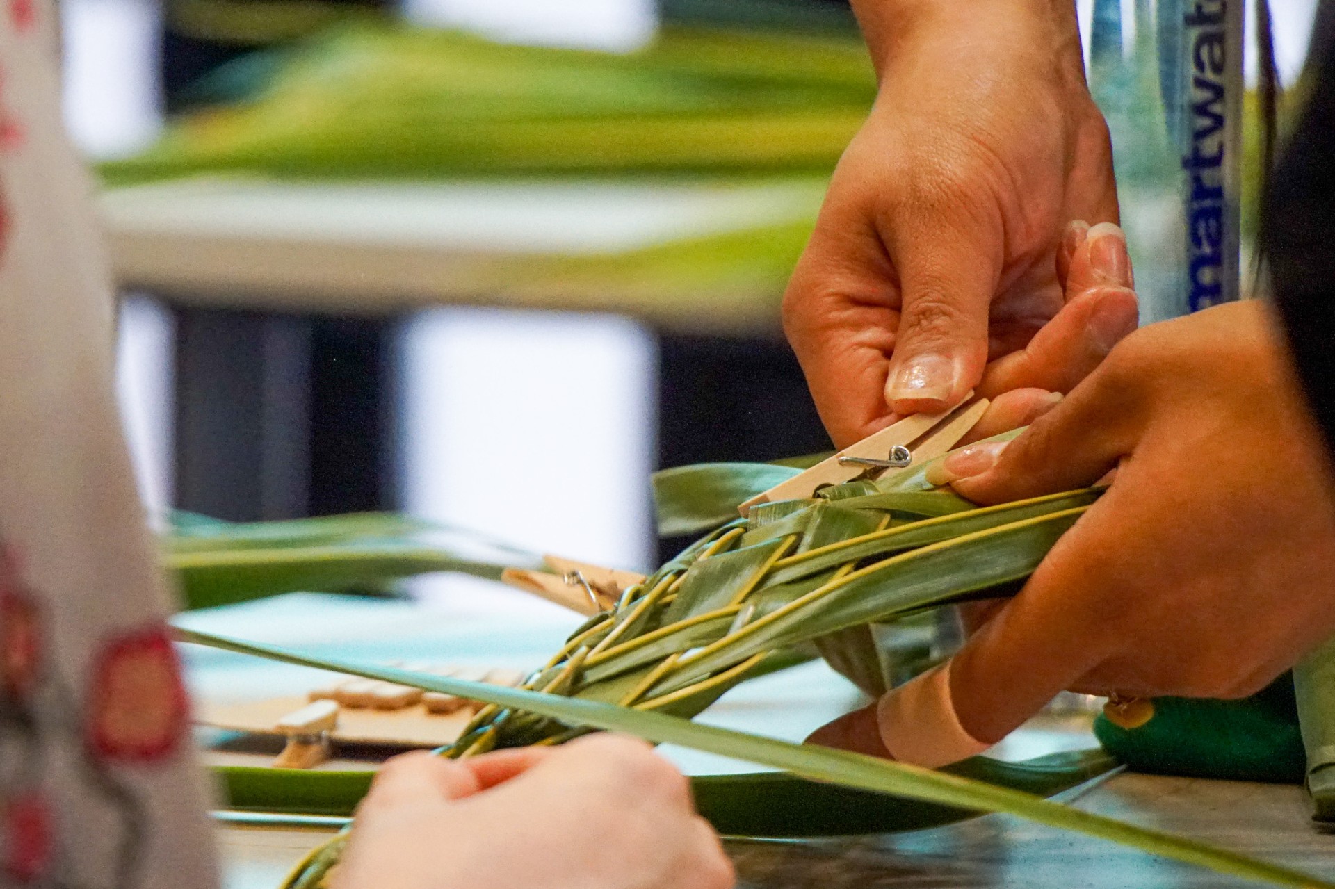 Hands weaving coconut leaves