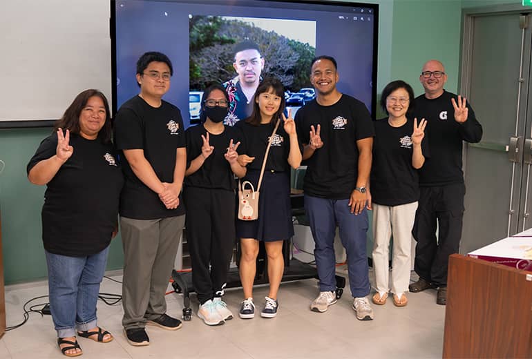 participants and faciliators of summer math program pose for a group photo, holding up peace signs